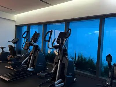 a gym with cardio machines in front of a window at Eaton suites KLCC at KL in Kuala Lumpur