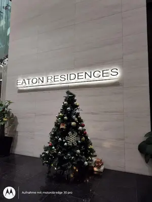 a christmas tree in front of a wall with a sign at Eaton suites KLCC at KL in Kuala Lumpur