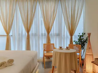 a bedroom with a bed and a table and windows at Scarletz Suites by Stevvy KL Home Stay in Kuala Lumpur