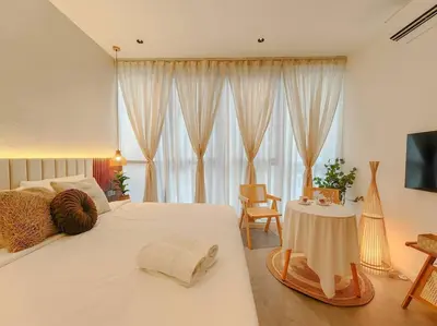 a bedroom with a large white bed and a table at Scarletz Suites by Stevvy KL Home Stay in Kuala Lumpur