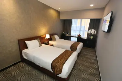a hotel room with two beds and a television at Metrostar Hotel Kuala Lumpur in Kuala Lumpur