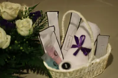 a basket with a bunch of items in it next to flowers at Metrostar Hotel Kuala Lumpur in Kuala Lumpur