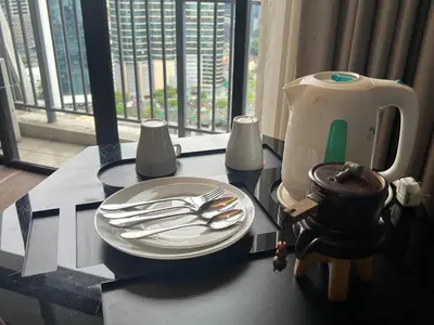 a table with a plate and utensils on it at ComfyHomes M101 Dang Wangi Pool KLCC View in Kuala Lumpur