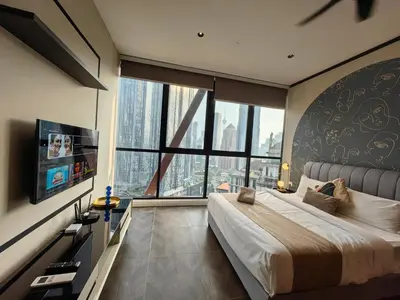 a bedroom with a large bed and a large window at Scarletz Suites KLCC by De Harlequins Guesthouse in Kuala Lumpur