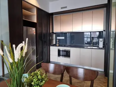 a kitchen with two chairs and a table in a room at Scarletz Suites KLCC by De Harlequins Guesthouse in Kuala Lumpur