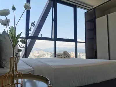 a bedroom with a white bed with a large window at Scarletz Suites KLCC by De Harlequins Guesthouse in Kuala Lumpur