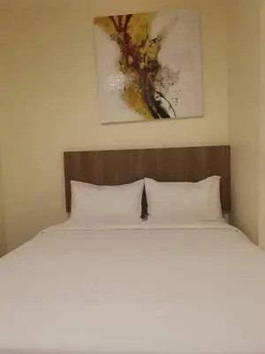 a bed with white pillows in a bedroom at SCC Hotel Chinatown in Kuala Lumpur