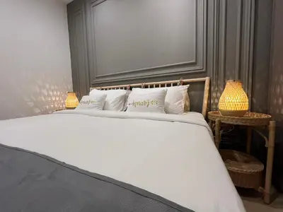 a bedroom with a white bed with two lamps at Eaton Residences KLCC by WSD in Kuala Lumpur