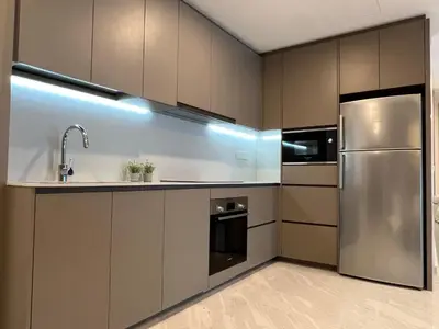 a kitchen with a stainless steel refrigerator and cabinets at Eaton Residences KLCC by WSD in Kuala Lumpur