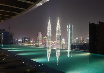 a swimming pool with a view of a city at night at Eaton Residences KLCC by WSD in Kuala Lumpur