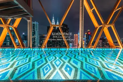 a pool with a view of the city at night at Scarletz Suites by Edenzpace @ KLCC Area in Kuala Lumpur