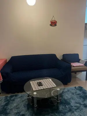 a living room with a blue couch and a table at Regalia Modern Studio in Kuala Lumpur
