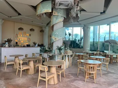 a restaurant with tables and chairs in a room with windows at Regalia Modern Studio in Kuala Lumpur