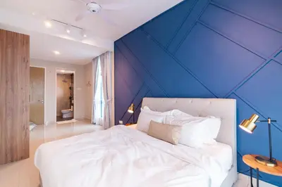a bedroom with a blue accent wall and a bed at Legasi @ Kampung Bharu in Kuala Lumpur