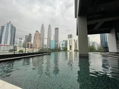 a pool of water with a city in the background at Legasi @ Kampung Bharu in Kuala Lumpur