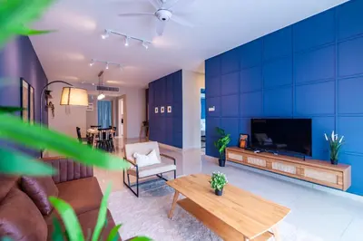 a living room with a large blue wall at Legasi @ Kampung Bharu in Kuala Lumpur