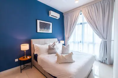 a blue bedroom with a large bed with white pillows at Legasi @ Kampung Bharu in Kuala Lumpur