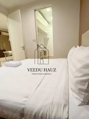 a white bed with a black sign on it at The Platinum KLCC by Veedu Hauz in Kuala Lumpur