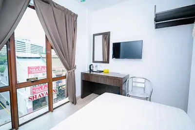 a bedroom with a bed and a desk and a tv at Swing & Pillows - Dataran Merdeka Kuala Lumpur in Kuala Lumpur
