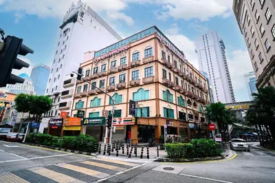 a tall building on a city street with a crosswalk at Swing & Pillows - Dataran Merdeka Kuala Lumpur in Kuala Lumpur