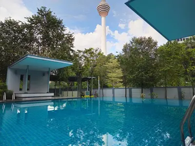 a swimming pool with a tower in the background at The Wisdom Apartment in Kuala Lumpur
