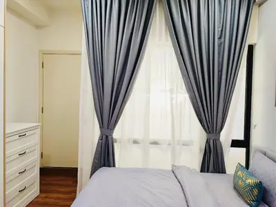 a bedroom with a large window with blue curtains at ARTE Mont Kiara Host By HOST CORNER SUITES in Kuala Lumpur