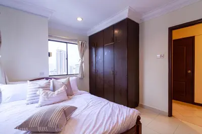a bedroom with a bed with white sheets and a window at Angkasa Impian 1 @ Bukit Bintang in Kuala Lumpur