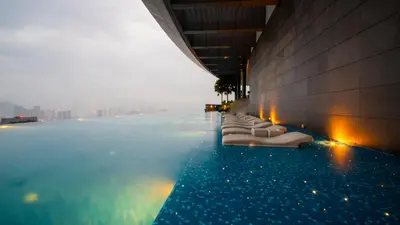 a infinity pool with a row of chairs in a building at MOONWAY SUITES At EATON KLCC in Kuala Lumpur