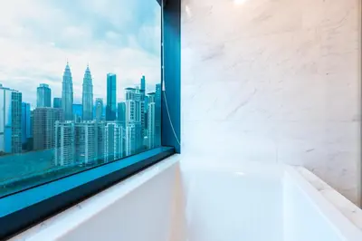 a bathroom with a window with a view of the city at MOONWAY SUITES At EATON KLCC in Kuala Lumpur