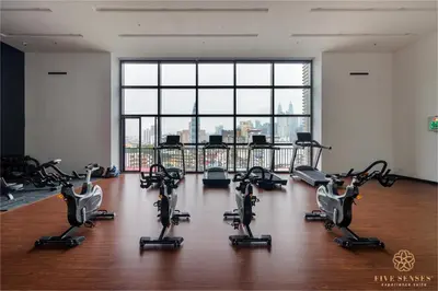 a gym with cardio equipment in a room with a large window at Chambers Residence Kuala Lumpur by Roam in Kuala Lumpur