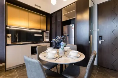 a dining room table with chairs and a kitchen at KLCC ModernMusicalSuite AT ScarletzSuites in Kuala Lumpur