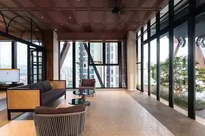 a living room with a couch and chairs and windows at KLCC ModernMusicalSuite AT ScarletzSuites in Kuala Lumpur