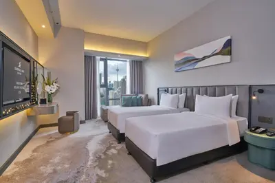 a hotel room with two beds and a tv at Sleeping Lion Suites in Kuala Lumpur