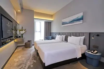 a hotel room with two beds and a flat screen tv at Sleeping Lion Suites in Kuala Lumpur