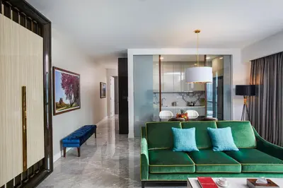 a living room with a green couch and a table at THE FACE Style Hotel in Kuala Lumpur