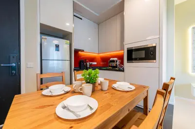 a kitchen and dining room with a wooden table at Arcoris Mont Kiara in Kuala Lumpur