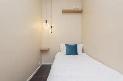 a bedroom with a bed with a blue pillow on it at Arcoris Mont Kiara in Kuala Lumpur