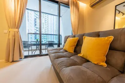 a couch with two yellow pillows in a living room at Arcoris Mont Kiara in Kuala Lumpur