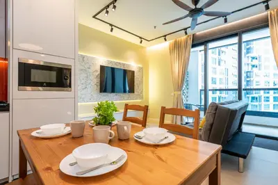 a dining room with a wooden table with plates on it at Arcoris Mont Kiara in Kuala Lumpur