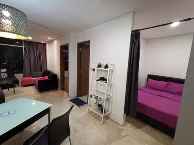 a living room with a purple bed and a table at Vortex Suites KLCC by C&C Fortune in Kuala Lumpur