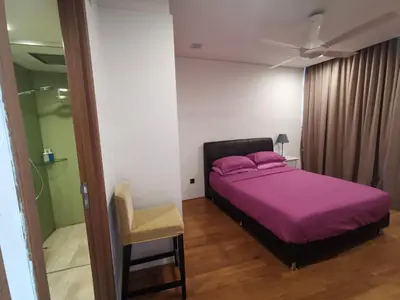 a bedroom with a purple bed and a chair at Vortex Suites KLCC by C&C Fortune in Kuala Lumpur