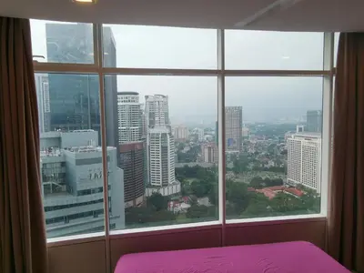 a bedroom with a view of a city from a window at Vortex Suites KLCC by C&C Fortune in Kuala Lumpur