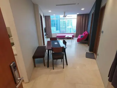 a dining room with a table and chairs and a living room at Vortex Suites KLCC by C&C Fortune in Kuala Lumpur