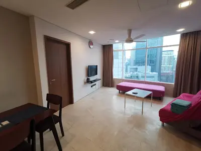 a living room with a pink couch and a table at Vortex Suites KLCC by C&C Fortune in Kuala Lumpur