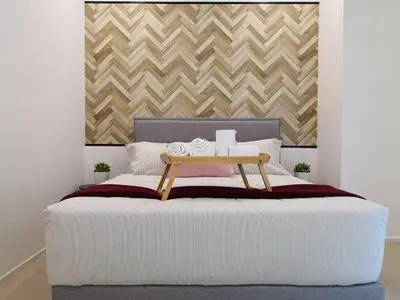 a bedroom with a white bed with a table on it at Arcoris Mont Kiara Kuala Lumpur in Kuala Lumpur
