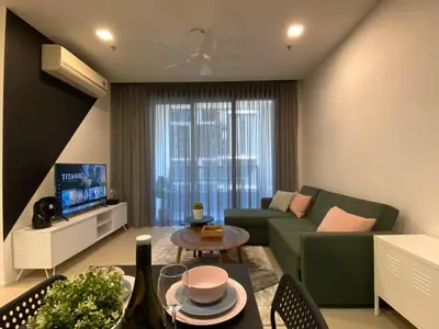 a living room with a green couch and a tv at Arcoris Mont Kiara Kuala Lumpur in Kuala Lumpur