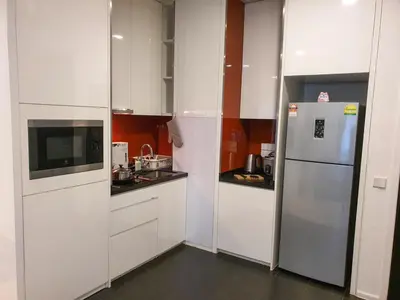 a kitchen with white cabinets and a refrigerator at Arcoris Mont Kiara Kuala Lumpur in Kuala Lumpur