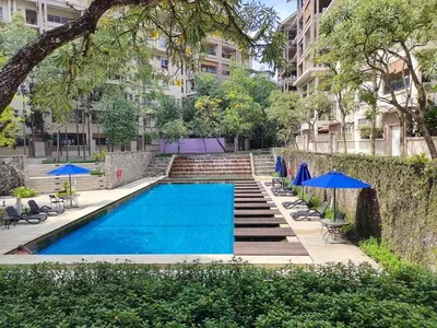 a swimming pool with chairs and umbrellas next to a building at Superior Maya Kuala Lumpur in Kuala Lumpur