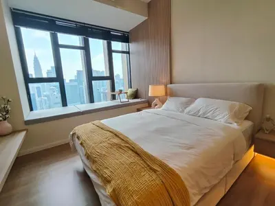 a bedroom with a large bed with a large window at Ceylonz Suites in Kuala Lumpur