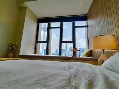 a bedroom with a bed and a large window at Ceylonz Suites in Kuala Lumpur